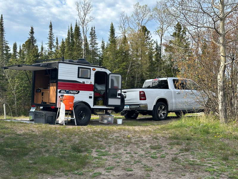 Scenic RV rental: White pickup & teardrop camper with open kitchen, parked in a forest setting for outdoor adventure. — photo 2