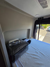RV rental interior features a prepared bed with new Natori Studio & Colette bedding. Ideal for comfortable travel.