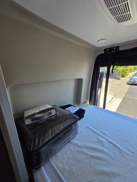 RV rental interior features a prepared bed with new Natori Studio & Colette bedding. Ideal for comfortable travel.