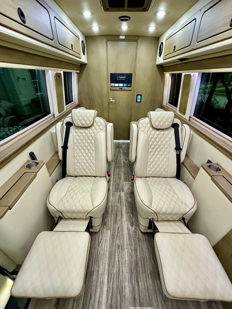  and a large entertainment screen.|Luxurious rv rental interior featuring quilted cream seats and a TV displaying YouTube TV — photo 6
