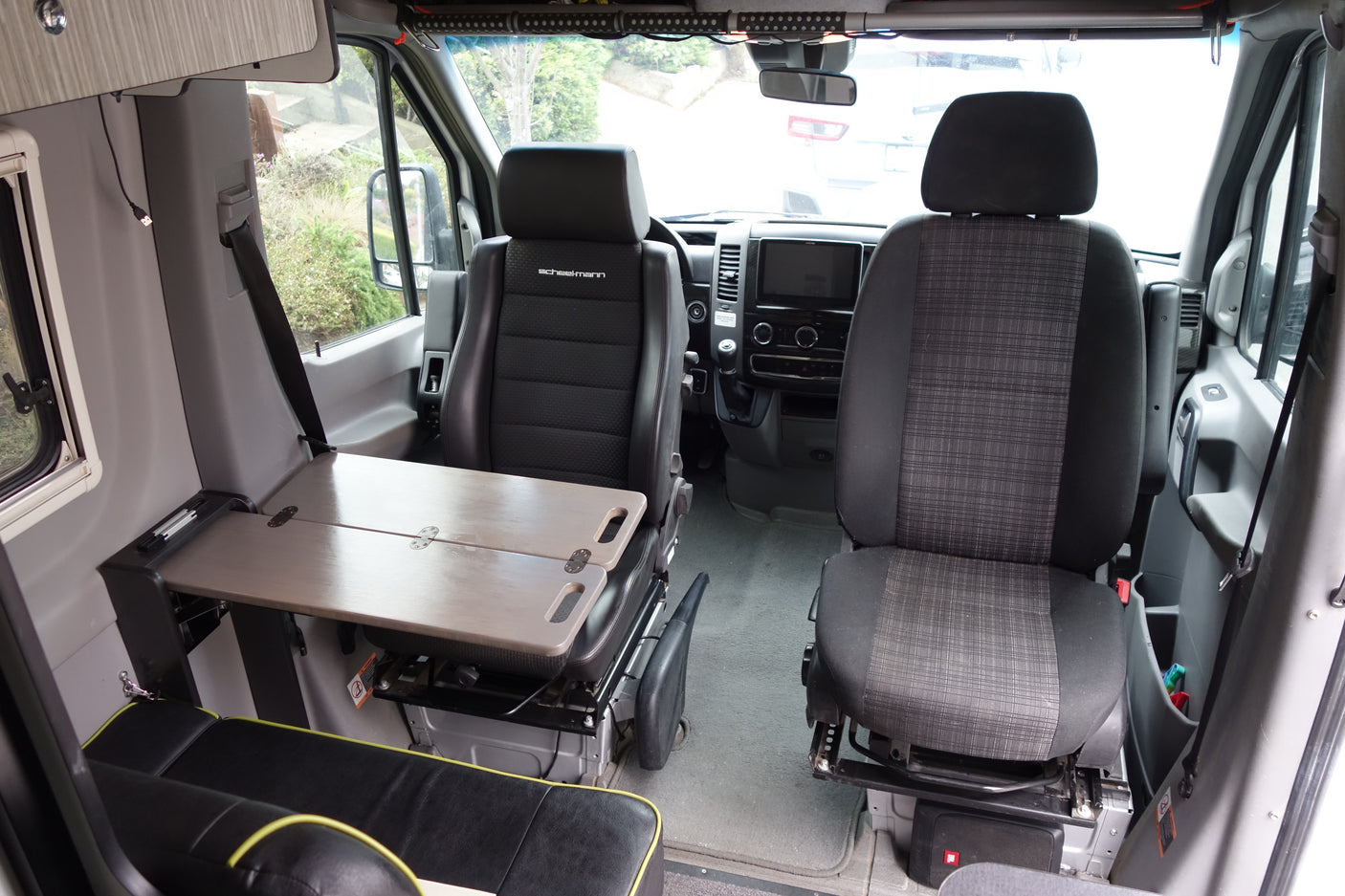 Explore the spacious interior of this RV rental, featuring comfortable seating, a versatile table, and a modern dashboard.