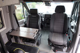 Explore the spacious interior of this RV rental, featuring comfortable seating, a versatile table, and a modern dashboard.