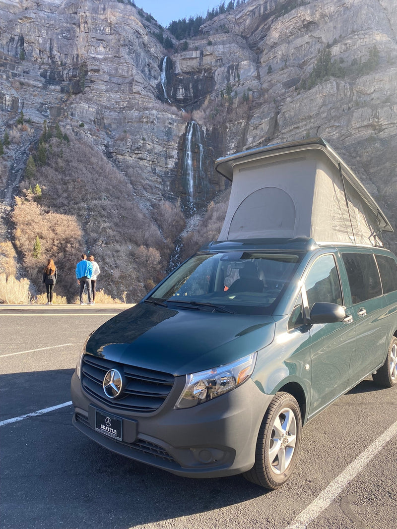 A green pop-top Mercedes-Benz camper van (RV rental) parked — photo 1