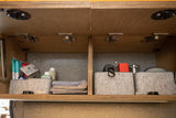 Efficient overhead storage in an RV rental: organized felt bins, toiletries, and travel essentials.