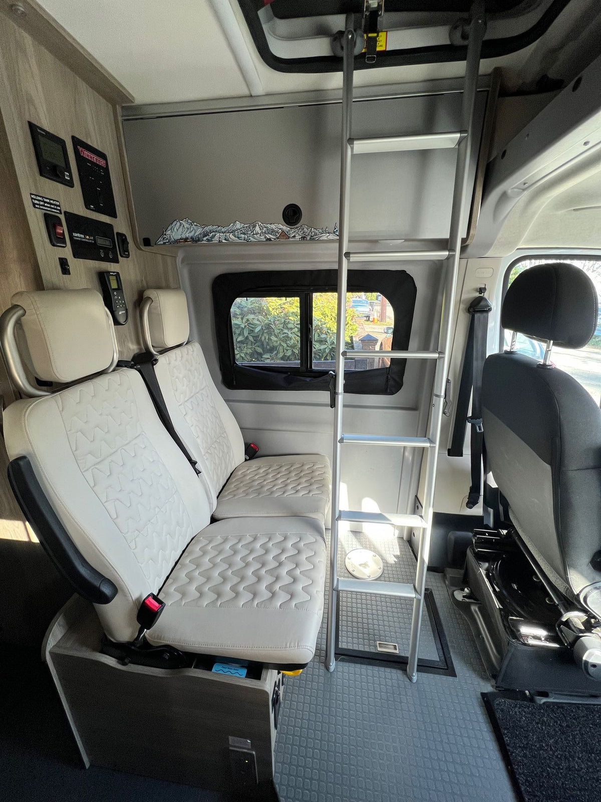  and capacities detailed.|RV rental camper van's clean front cab — photo 8
