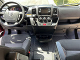 RV rental interior: front cabin with steering wheel, dashboard, gear shift, and both front seats visible.