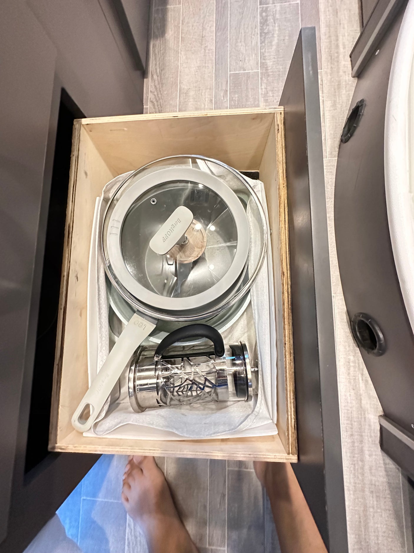 Organized rv rental kitchen drawer: a pot, pan, and French press neatly stored for travel cooking.