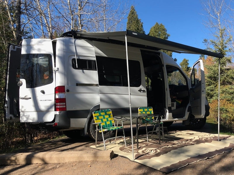  and side storage bags for van life comfort.|Cozy RV rental interior shows a bed by a window — photo 10