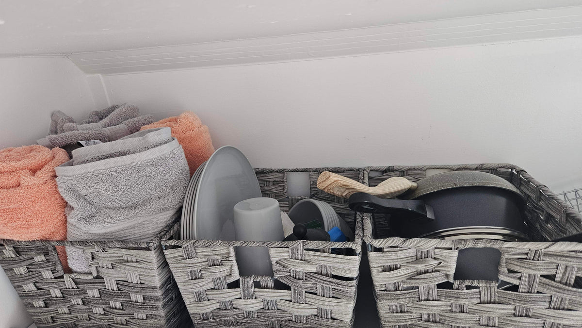 Organized rv rental storage: grey baskets hold soft towels, grey dishes, and cooking pots, ready for your trip. — photo 14