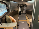 RV rental interior: convertible seating, a floor-mounted table base, and practical storage enhance compact travel.