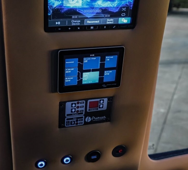 This RV rental's control panel displays infotainment, power management (99% battery, solar, loads), Premier Products climate control, and USB ports. — photo 13