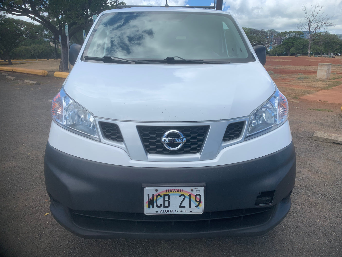Hawaii RV rental: White Nissan van with license plate WCB 219, parked outdoors.