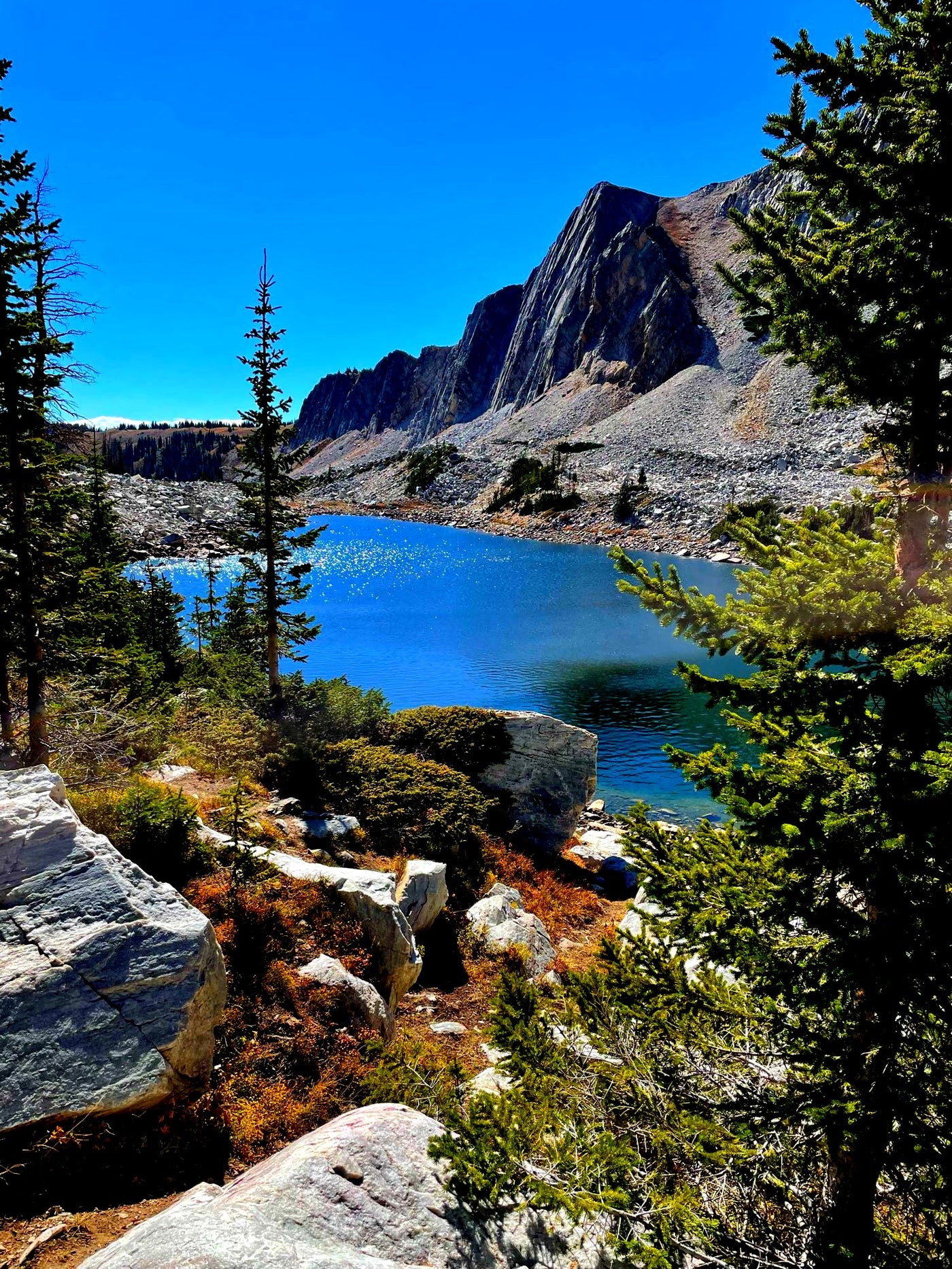 Explore this serene mountain lake with rocky shores & majestic peaks, framed by evergreens. Your RV rental adventure! — photo 6