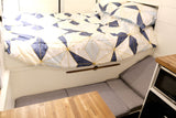 RV rental: Compact interior with comfy bed, adaptable seating, and built-in microwave.