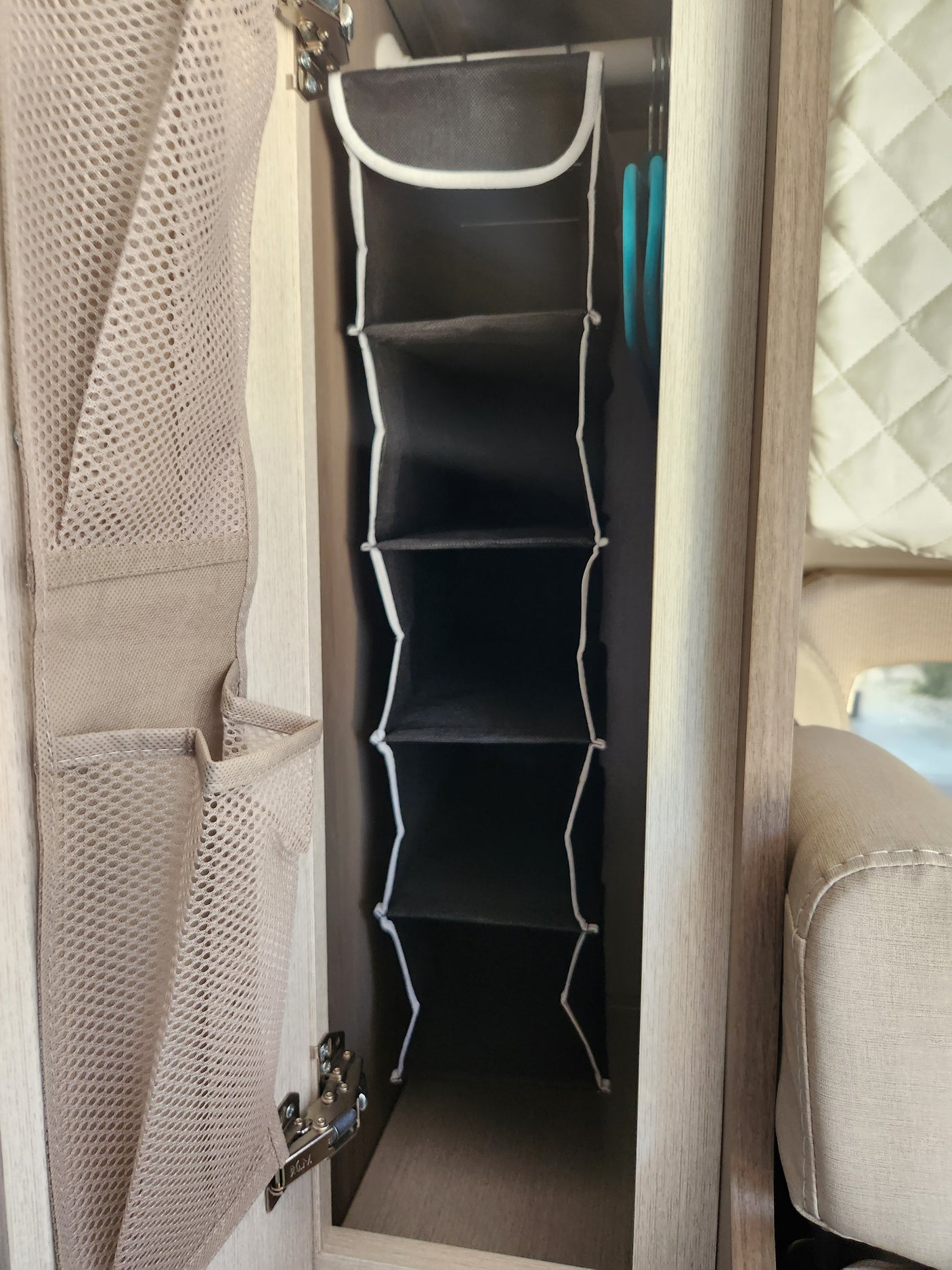 RV rental cabinet storage: A black multi-compartment organizer and a beige mesh bag for efficient space use.
