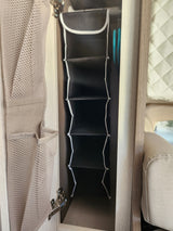 RV rental cabinet storage: A black multi-compartment organizer and a beige mesh bag for efficient space use.