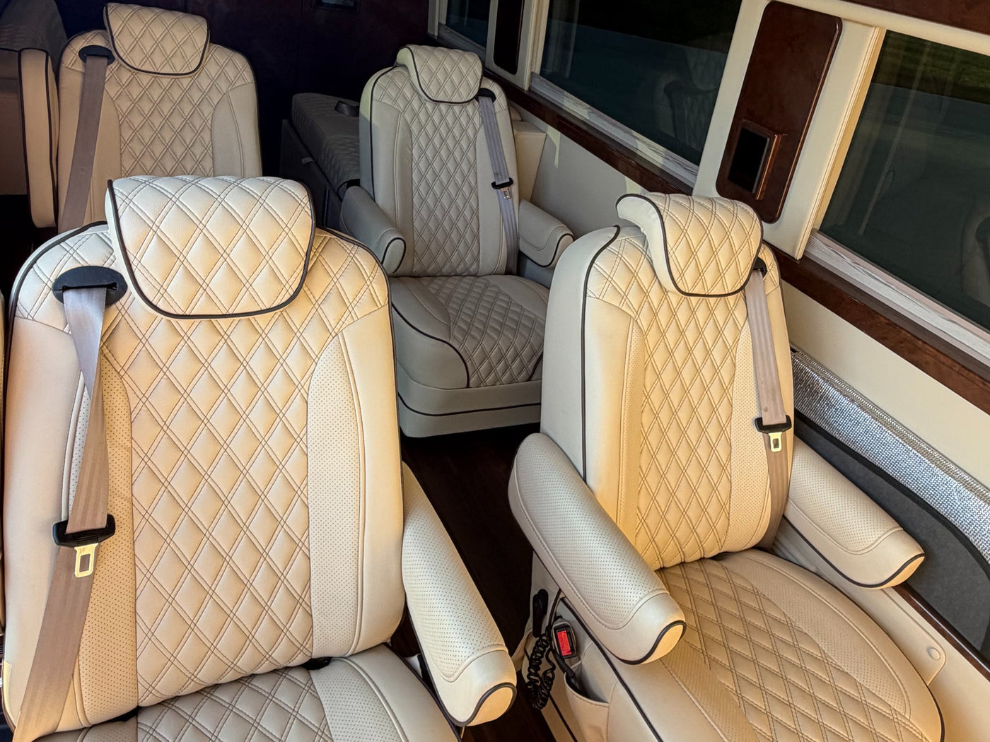  perfect for a high-end rv rental. Parked at sunset with glowing headlights.|Spacious RV rental interior with custom tan quilted leather seats — photo 5