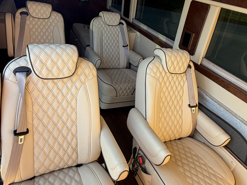  perfect for a high-end rv rental. Parked at sunset with glowing headlights.|Spacious RV rental interior with custom tan quilted leather seats — photo 5