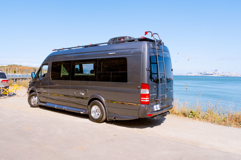 Dark gray Winnebago Era RV rental parked by the San Francisco Bay with a yellow bike, ideal for scenic travel. — photo 14