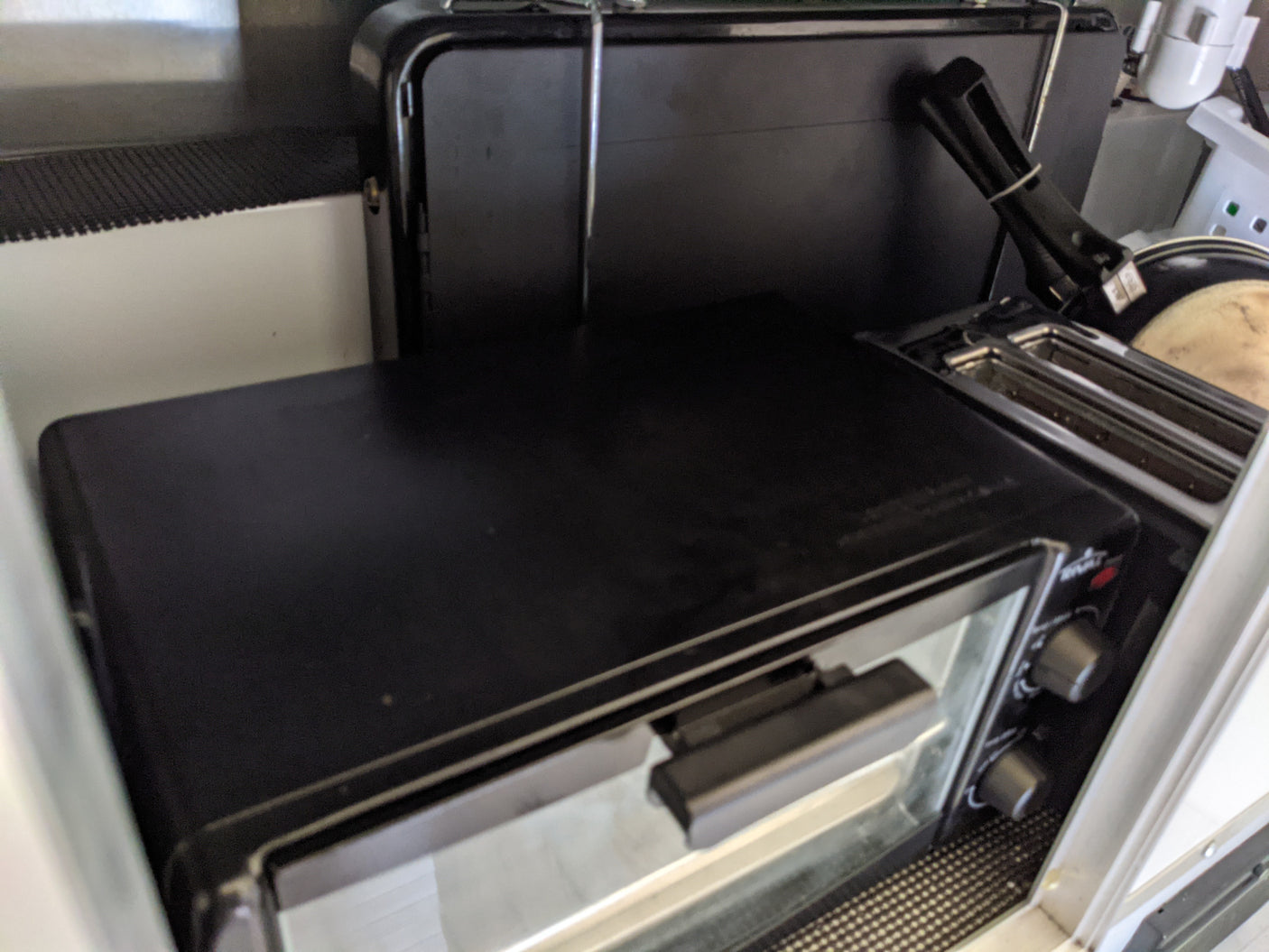 Compact cooking appliances in an RV rental, featuring a black toaster oven and a slot toaster.