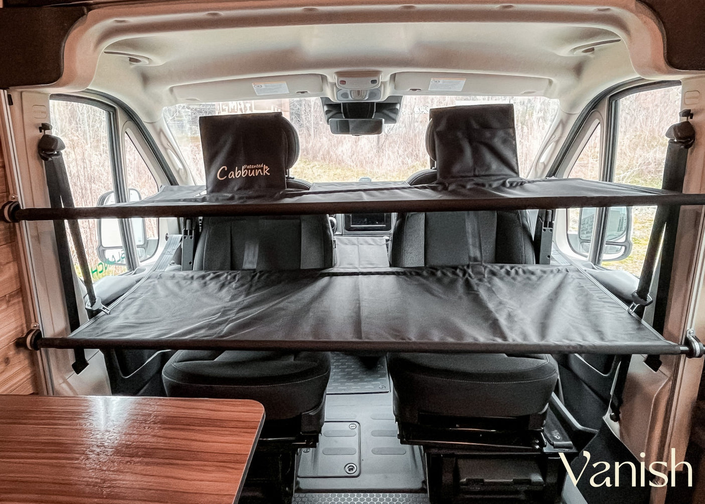 Inside this RV rental, a suspended dark grey "Cabbunk" provides an overhead bunk bed or storage in the front cab area.