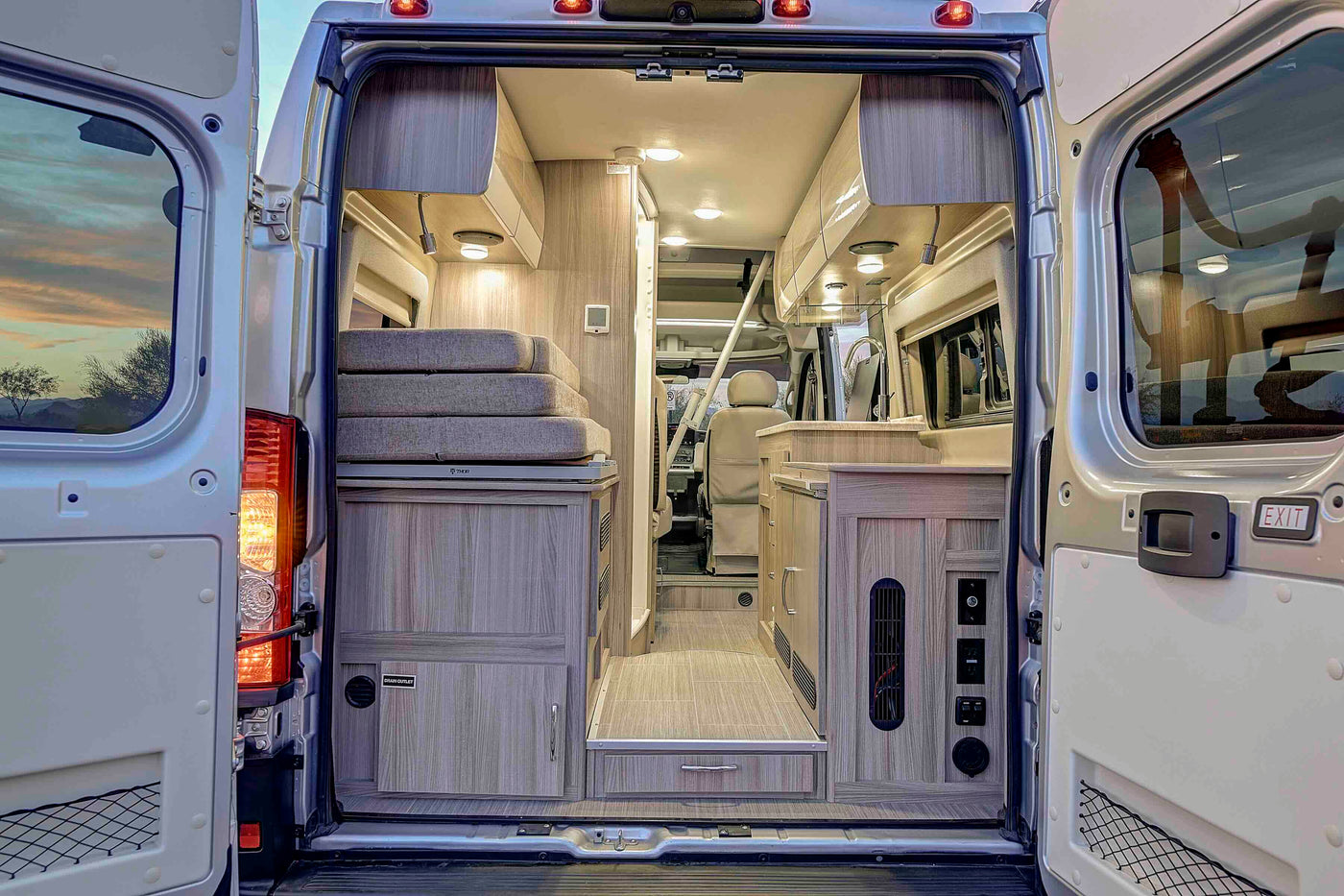  and a glimpse of the rear bed and shower.|Modern RV rental camper van with open side door — photo 12