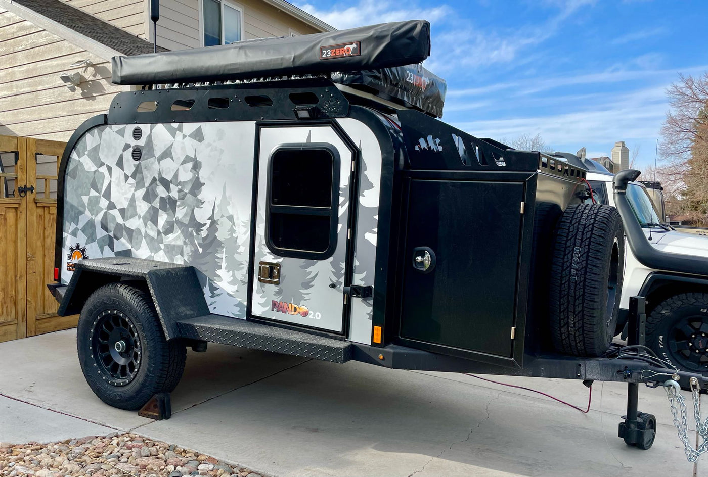  and propane for adventure camping.|Off-grid RV rental: Toyota FJ Cruiser towing a camper trailer with an open outdoor kitchen and rooftop tent.|Explore off-road with this Pando 2.0 adventure trailer — photo 4
