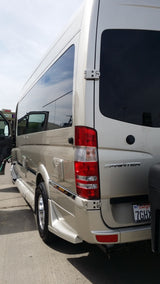 Rear three-quarter view of a light-colored Mercedes Sprinter van, likely an rv rental, with tinted windows and a California plate.