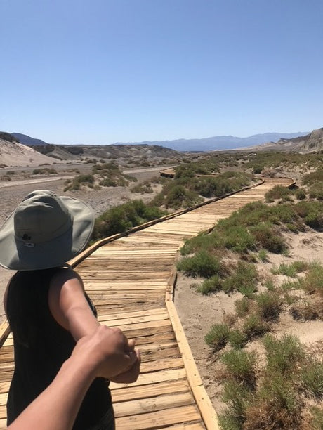 Holding hands, walking a desert boardwalk through a scenic landscape. Great for an RV rental adventure!