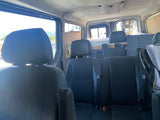 Cozy RV rental interior: view from front seats showing spacious rear seating and a neatly set up bed area.