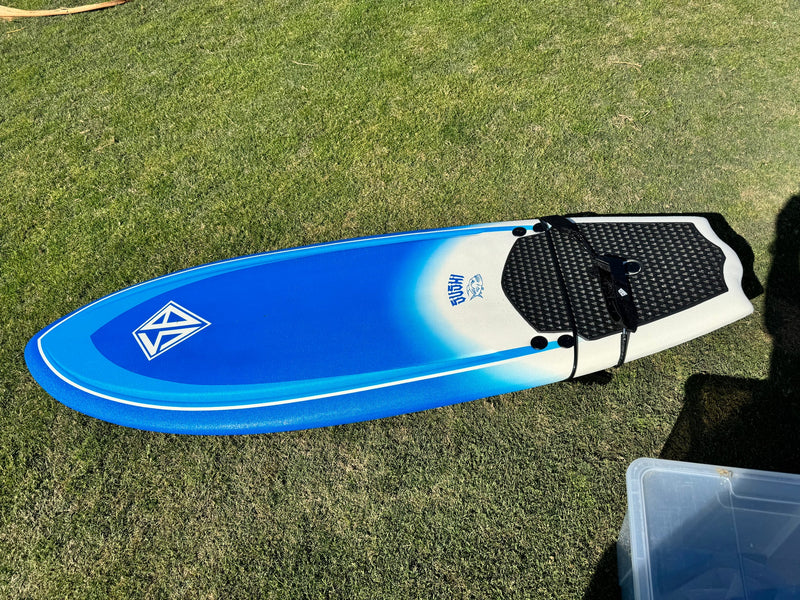A blue and white surfboard rests on green grass. Imagine this fun with an RV rental adventure! — photo 12
