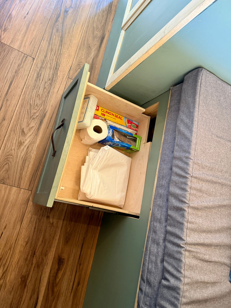 Open drawer in an RV rental, neatly stocked with kitchen essentials like cling wrap, Ziploc bags, and paper towels. — photo 16
