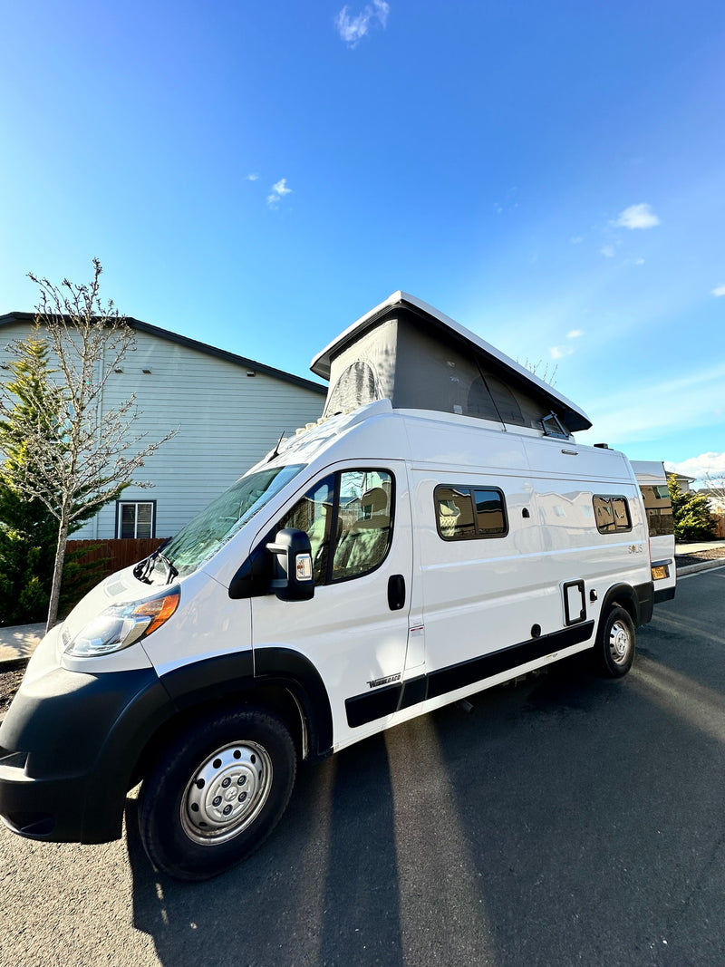  and firewood on gravel under a cloudy sky.|Explore Oregon! White Winnebago Ram ProMaster camper van RV rental parked on a sunny street — photo 13