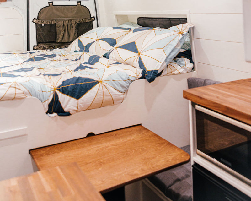  featuring a compact kitchen and comfy bed.|Step into a cozy RV rental! This camper van interior features a comfy bed — photo 12