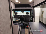 Inside this RV rental, the front cabin features swivel seats, a dining table, and compact living area.