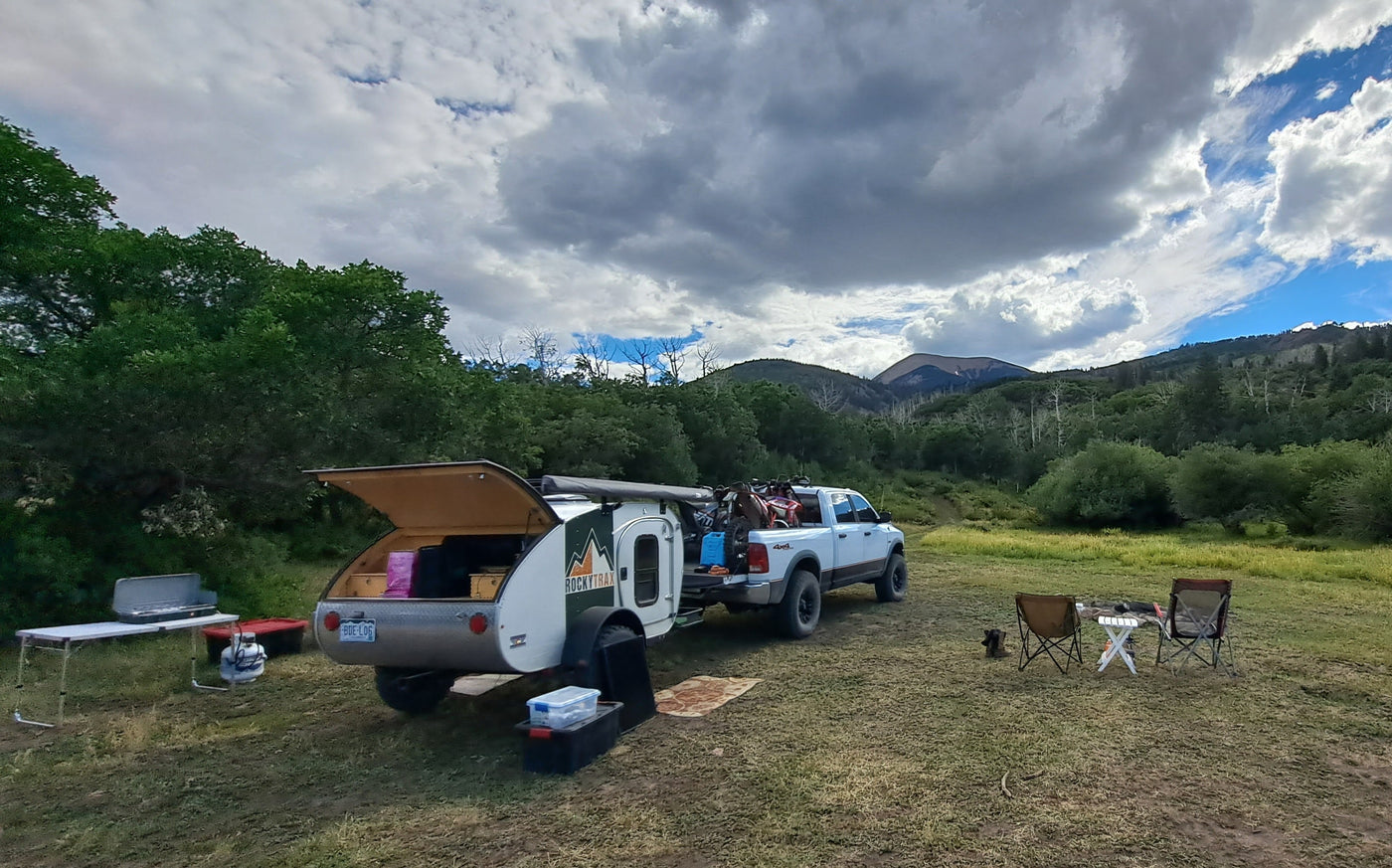 RV rental: Teardrop camper & truck camping setup in a lush mountain valley under cloudy skies, perfect for adventure! — photo 2