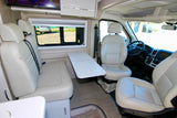 Bright and airy rv rental interior featuring cream leather seats, a movable table, and a TV for travel comfort.