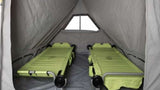 RV rental interior shows two lime green cots in a grey tent-like camper, offering a comfortable sleeping area.