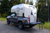 A rugged Toyota Tacoma with a Kimbo truck camper, ideal for your next outdoor adventure or RV rental.