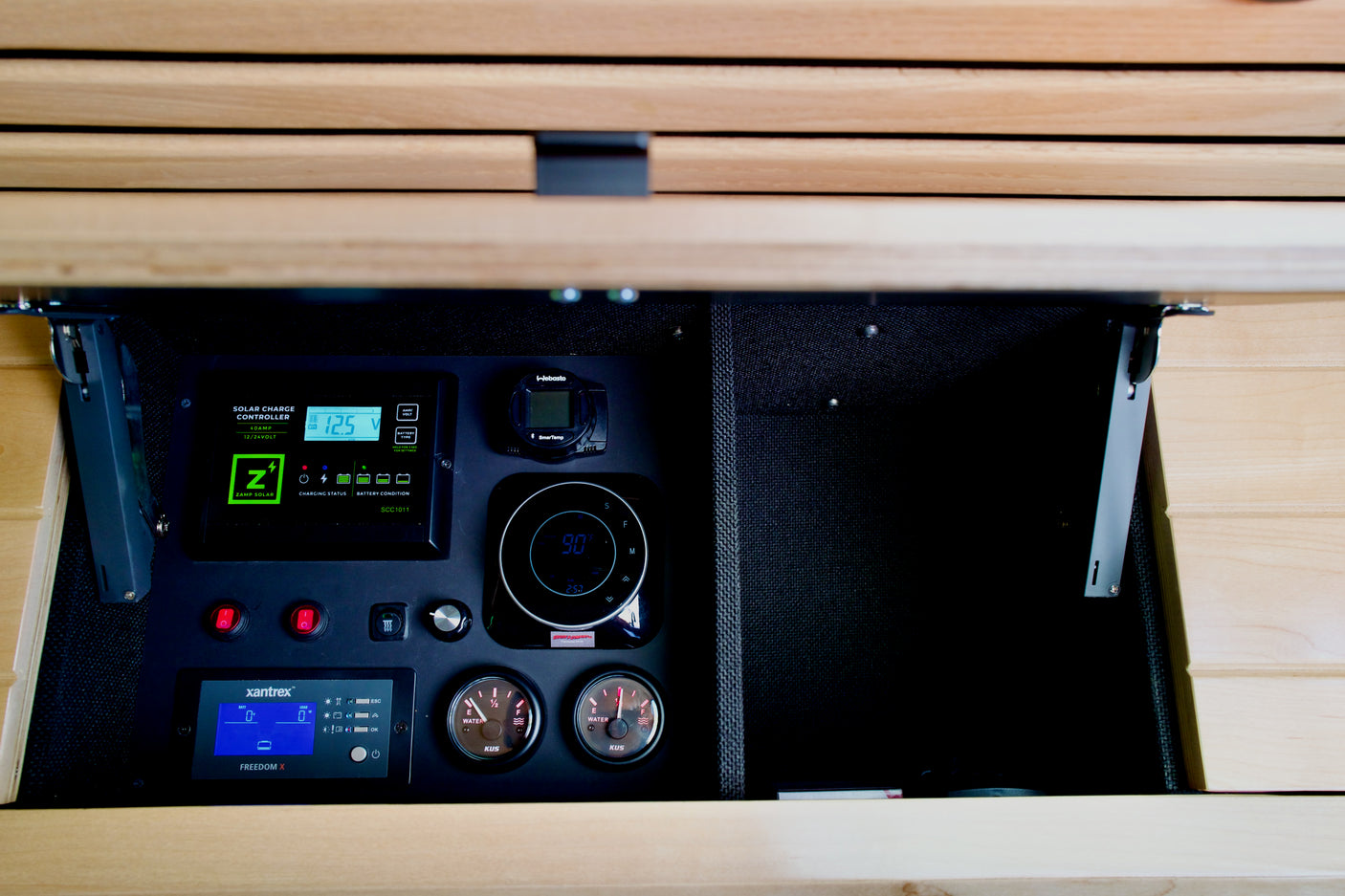 RV rental control panel: solar charge controller, Webasto heater, Xantrex inverter, and water gauges for full system oversight.