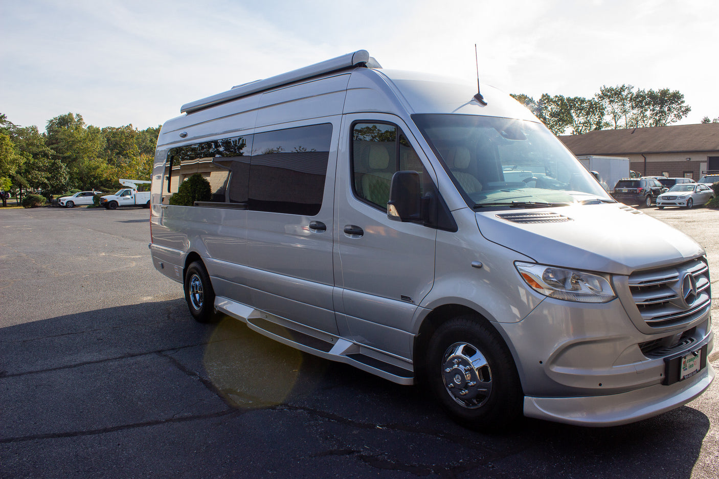 Silver Mercedes-Benz Sprinter RV rental: a sleek camper van parked on a sunny day.
