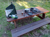 Enjoying outdoor cooking with an RV rental! Picnic table holds camping stove, propane, cookware, and spices.