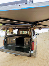 A Toyota Tundra pickup, perfect for an rv rental, highlights its custom overland camping setup with storage, fridge, and awning.