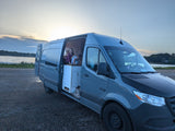 Kids enjoy an RV rental campervan by a serene lake at sunset, perfect for family adventures and van life.