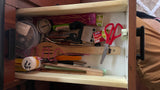 Cluttered RV rental kitchen drawer: utensils, matches, scissors, and tools. A versatile storage solution for compact living.
