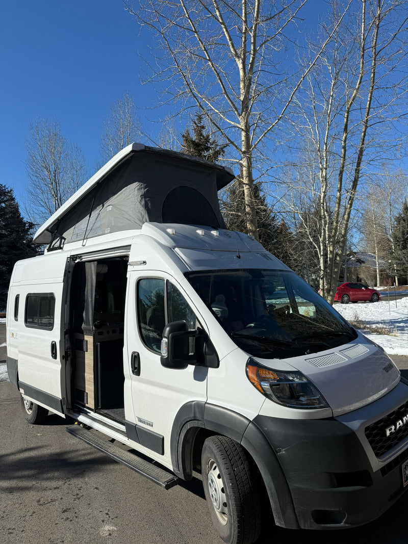 White pop-top camper van with open side door, ready for your rv rental. Sunny winter day, bare trees in background. — photo 4