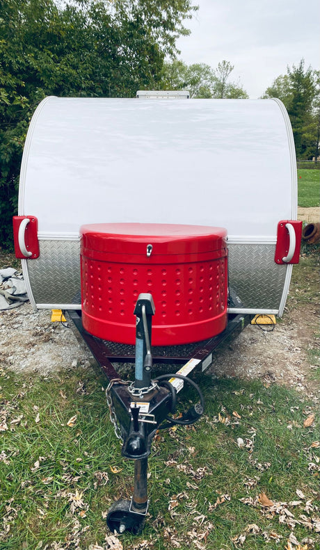 White teardrop RV rental featuring a prominent red front storage box, ideal for camping adventures.