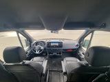 Detailed front view of a clean Mercedes-Benz Sprinter van interior, perfect for an RV rental. Dashboard, steering wheel, and navigation are visible.