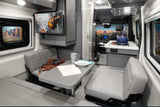 RV rental: The cozy, modern interior of a camper van with dining, kitchen, and wall-mounted TV.