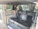 Experience comfort in this RV rental! Spacious van interior with black passenger seats, seatbelts, and a versatile sleeping area.